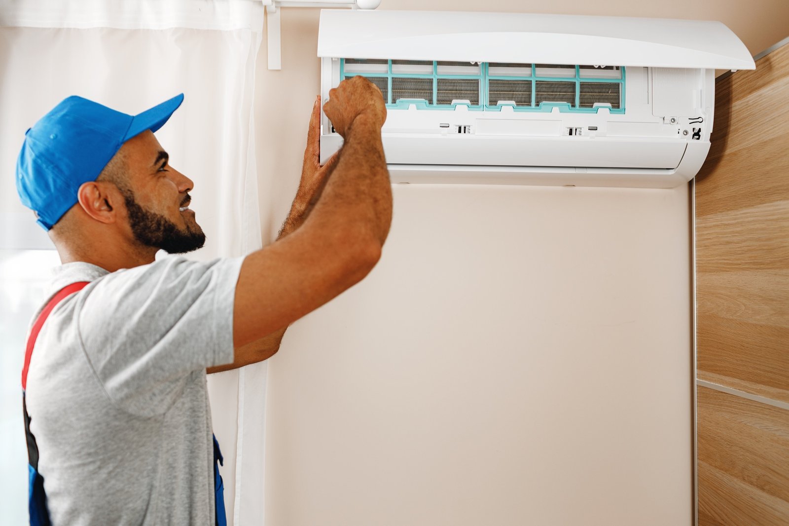 Professional repairman installing air conditioner in a room